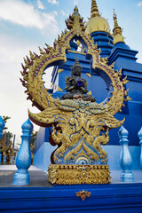 Black buddha statue holding a blue crystal ball inside a Rong Suea Ten temple in Thailand. (blue temple).