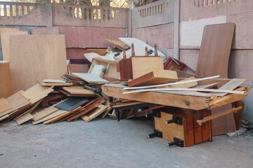 discarded old furniture in the garbage: bedside tables, boards, beds