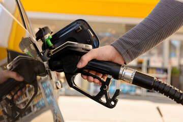 Car refuelling on the petrol station. Man refilling the car with fuel. Close up view. Gasoline,...