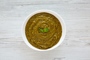 Homemade Green Pesto in a White Bowl, top view. Flat lay, overhead, from above.