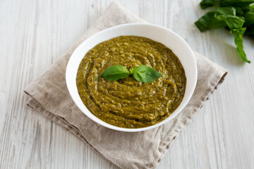 Homemade Green Pesto in a White Bowl, side view.