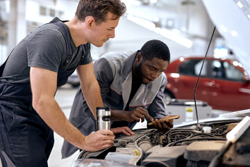 diverse Caucasian and black Men mechanic inspection checking bug in engine from application...