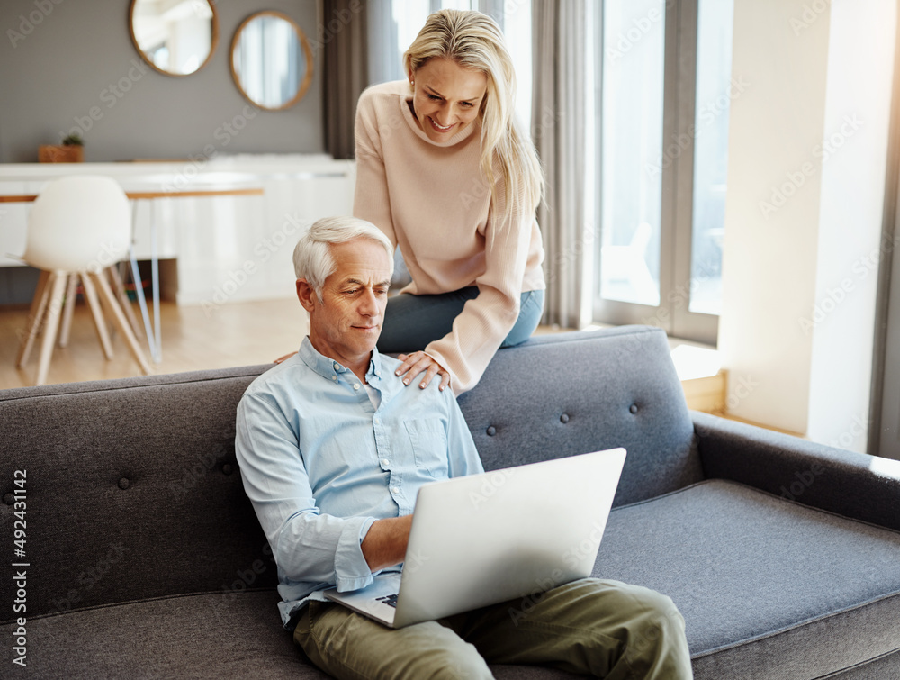 Poster getting more out of retirement by staying current. shot of a mature couple using a laptop on the sof