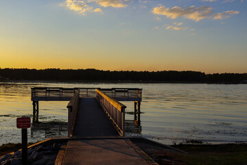 Obraz premium Watching the sunset from the pier at the lake.
