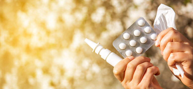 Woman holding allergy pills, drugs and nose spray against kind of an allergies during spring time, helathcare concept