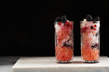 Two long glasses with non-alcoholic mocktail version of the classic blackberry and gin cocktail...