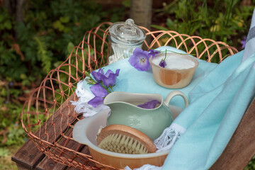 Spa items outdoors in garden in blue and purple colours with jug of water and basin. 