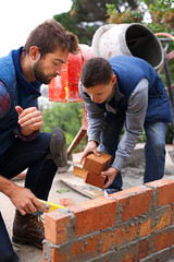 Making strong foundations together. Shot of bricklayers at work. - obrazy, fototapety, plakaty