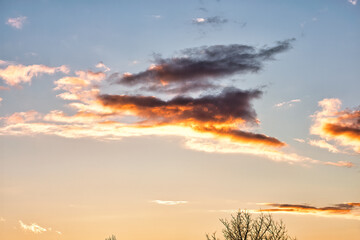 A bright sunset on the background of cloudy sky.