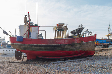 Red fishing boat obn a pebble beach