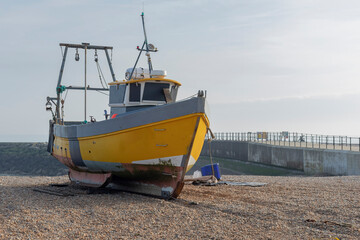 Yellow fishing boat on a beach on the UK South coast