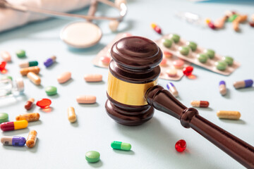 Health Medicine and Law. Judge gavel and medication on blue background, close up