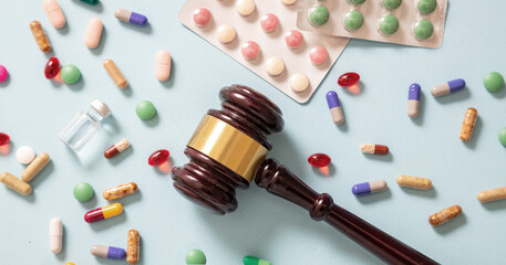Health Medicine and Law. Judge gavel and medication on blue background, top view
