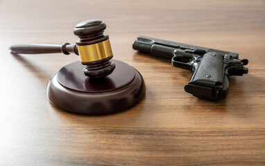 Judge gavel and handgun on lawyer office, close up. Crime, murder punishment concept.