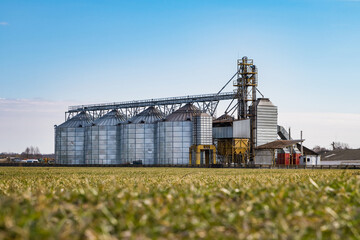 Obraz premium agro silos granary elevator on agro-processing manufacturing plant for processing drying cleaning and storage of agricultural products, flour, cereals and grain.