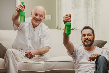 Two men celebrating toasting with bottles of beer