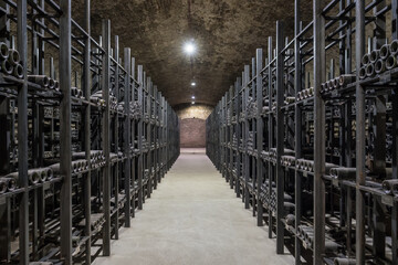 Very old dusty wine bottles in an underground cellar.