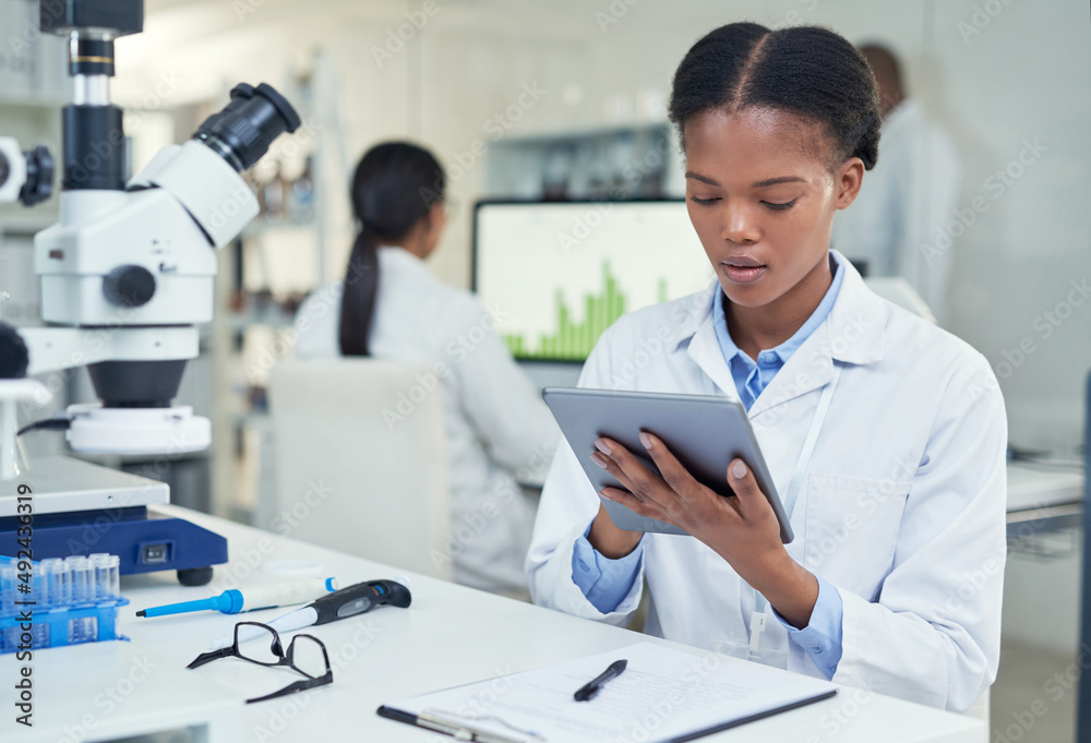 Aufkleber Sharing all her data in an instant. Shot of a young scientist using a digital tablet in a lab.