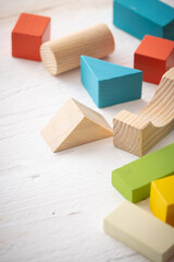 Colorful wooden toy blocks on white wooden table background. Natural materials. Healthy childhood....
