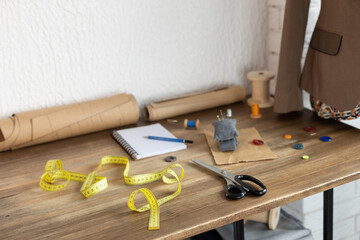 Thread spool with sewing tools on table. Concept of clothes atelier
