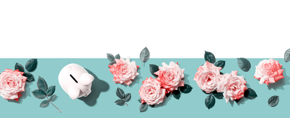 Piggy bank with pink roses overhead view - flat lay
