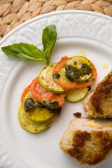 Juicy fresh cutlet cut into pieces with fresh fried tomatoes and zucchini.