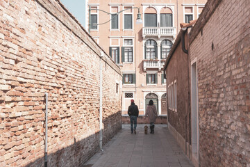 Small Venetian alley with two passers-by.