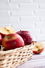 Fresh apples isolated in basket on wooden background under bright sunlight. Fresh natursl product. Harvest of apples. Little basket with harvest of fruit. Spring. Food. Close up