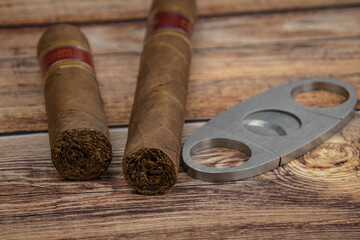 Straight cutter (or Guillotine) and cigars on wooden background.