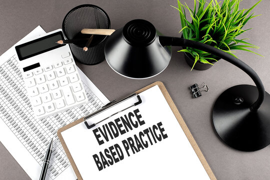 Clipboard ,chart and calculator, lamp and workspace accessories on a grey table. Top view , text EBP Evidence-based practice