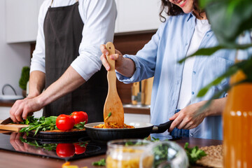 Closeup female and male hands are cooking dishes in kitchen. Young couple in love spends their leisure time together at home. Quarantine mood. Stay at home. Relationships between woman and man.