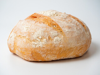 A close-up of a whole fresh crispy delicious round-shaped wheat bread on a white background....