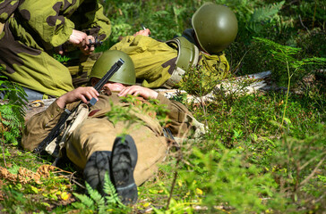 A Soviet soldier sleeps at a halt in the forest. Soldier's rest on the grass. Reenactor of the...