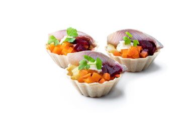 Herring salad with colorful vegetables in small tartlet isolated on white