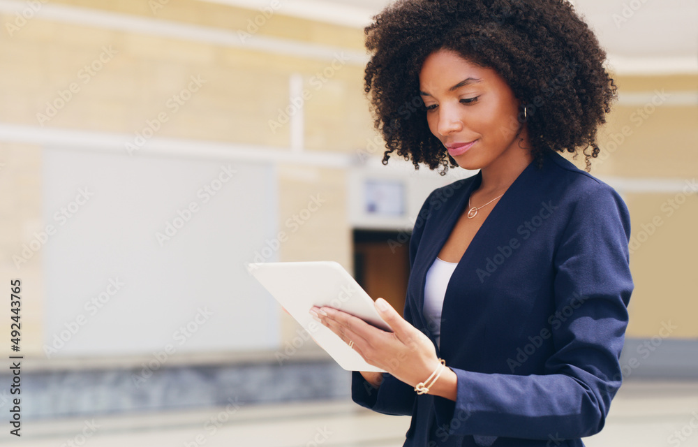 Poster going through my emails. cropped shot of an attractive young businesswoman standing alone and using 