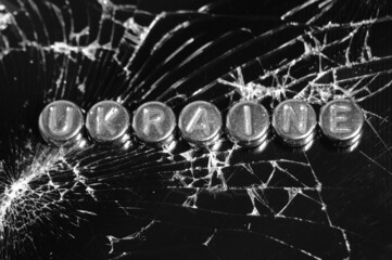 The word Ukraine on the background of broken glass.