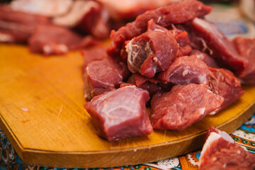 A slide of raw meat cut into pieces. Fresh beef. Preparation for cooking.
