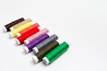 Close-up of colourful thread spools on white background. Studio photo.