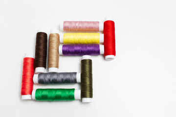 Close-up of colourful set of thread spools on white background.