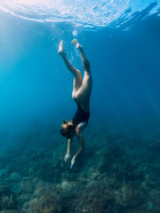 Naklejka na ściany i meble Woman underwater in sea. Freediving and beautiful lady in ocean