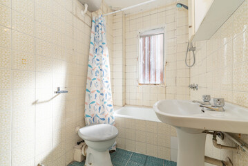 Vintage bathroom with kitsch tiles, bathtub and white porcelain toilets