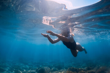 Sporty woman in bikini swimming in blue ocean. Activity summer days in sea