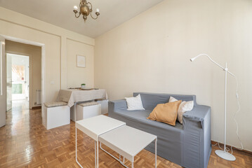 Living room with gray sofa, dining table, white and gray coffee table and French oak parquet flooring
