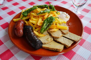 Plato de los montes con pimientos, lomo, huevo, morcilla, chorizo y patatas fritas caseras