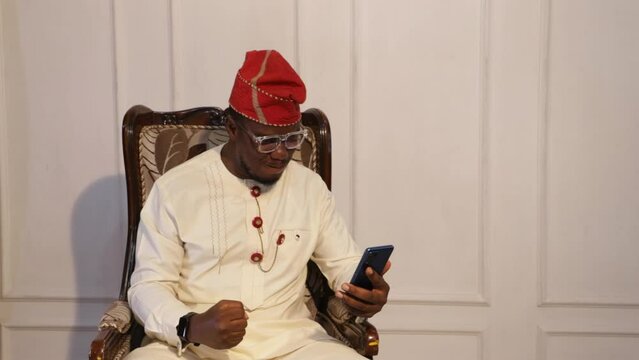 African Yoruba business man gives a thumbs up to good news on a blue phone