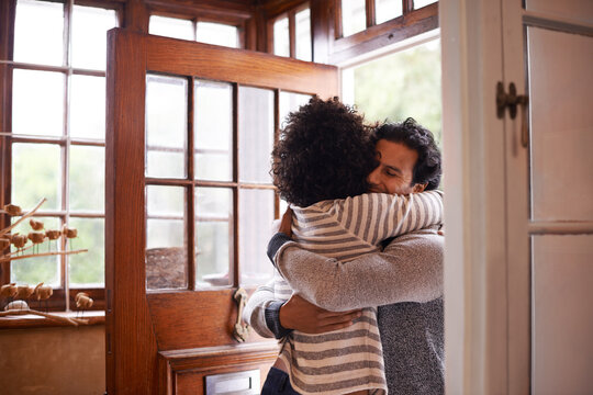 I missed you. Cropped shot of a young woman greeting her husband at the door.