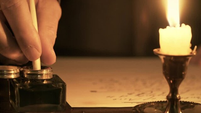 The focus of this 1700s scene is on an inkwell into which a man is dipping his quill pen to get ink for writing his letter.