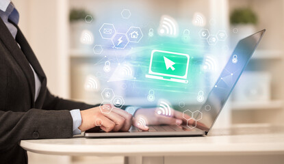 Hands working on laptop with digital icons