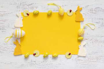 Yellow Easter background yellow eggs, flowers and rabbits. Greetings card. Copy space