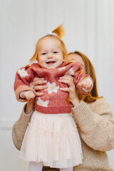 Cute mom and baby daughter play and hug. games with children. 